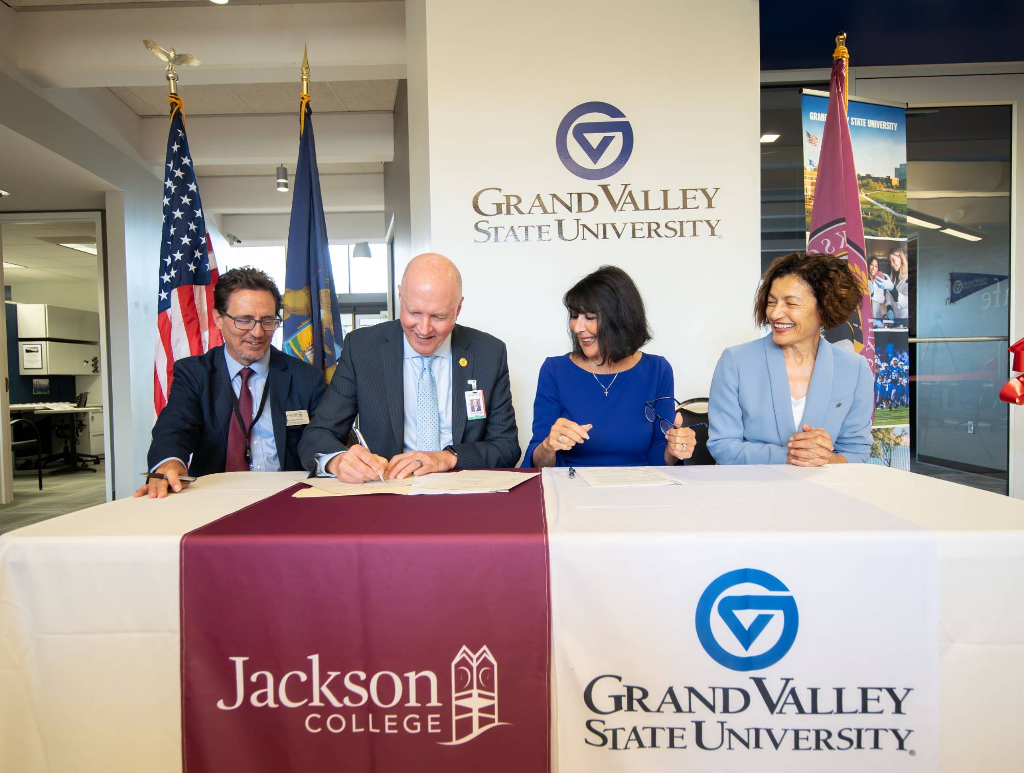 GVSU and Jackson College leaders sitting at a table signing documents
